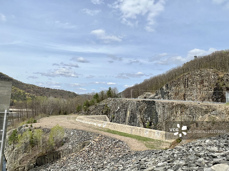 岩石景观，水坝和森林在多云的天空下，美国图片素材