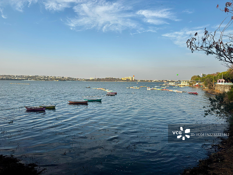 在蓝天映衬下，船只漂浮在宁静的湖面上图片素材