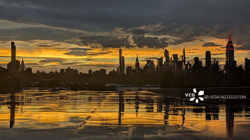纽约市天际线在戏剧性的日落背景下的剪影图片素材