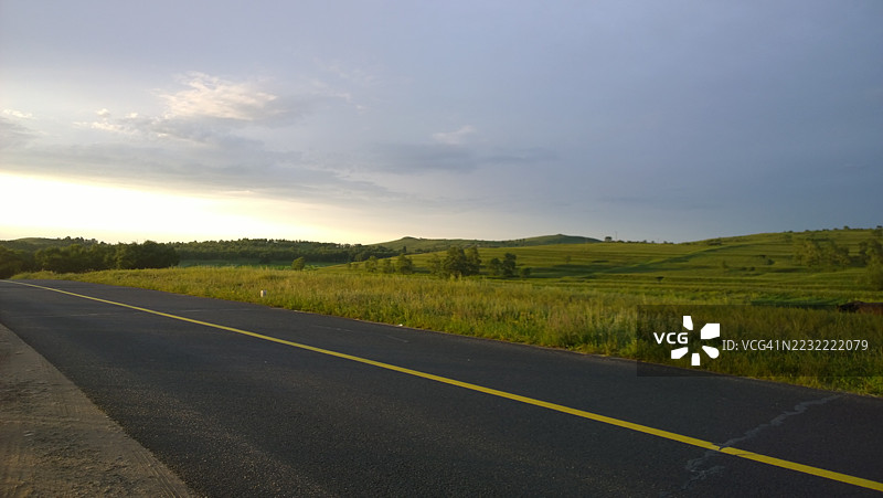日落时分，张家口市的起伏草原上的风景道路图片素材