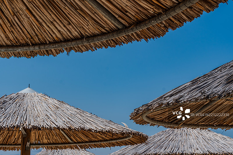 希阿索斯，希腊，蓝天下的茅草伞顶图片素材
