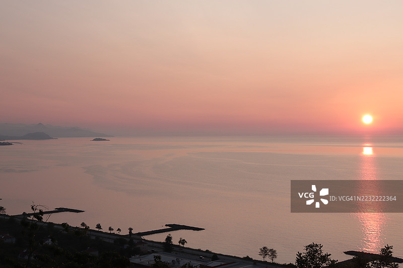 宁静的日落映照在平静的海面上图片素材
