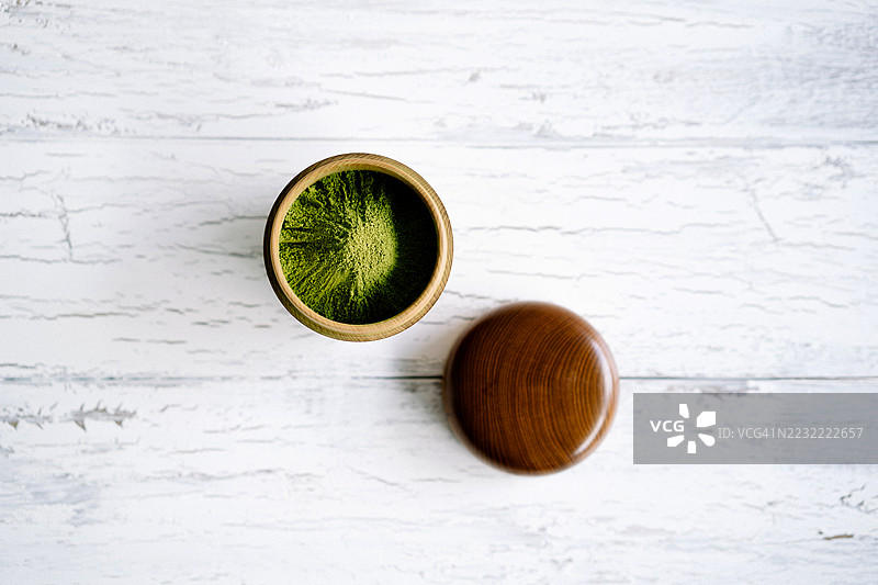 白色桌子上木碗里的抹茶粉俯视图图片素材
