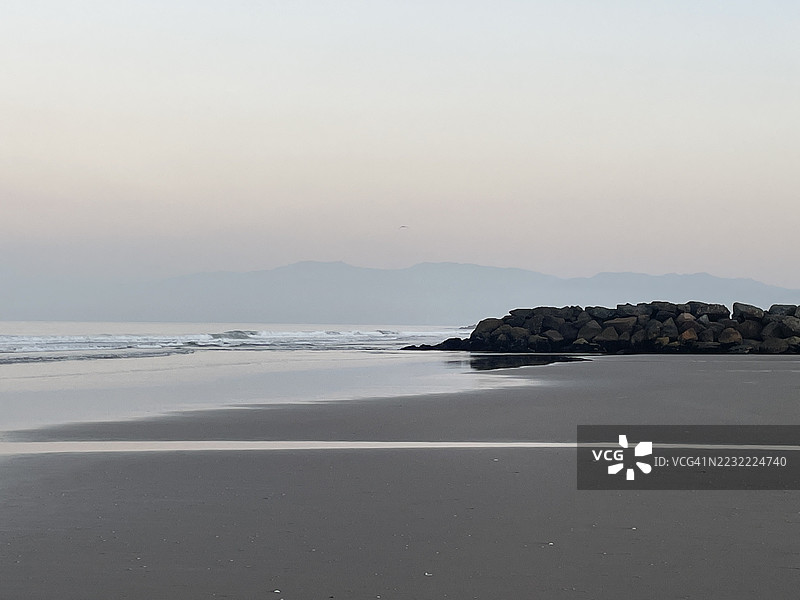 黄昏时分宁静的海滩场景，轻柔的海浪和岩石海岸线，洛杉矶，美国图片素材