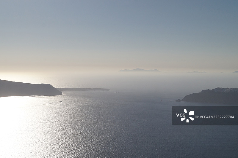 宁静的海洋景观，远处有岛屿和晴朗的天空，圣托里尼，希腊图片素材