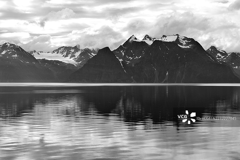 雄伟的雪山倒映在宁静的湖泊中，挪威图片素材