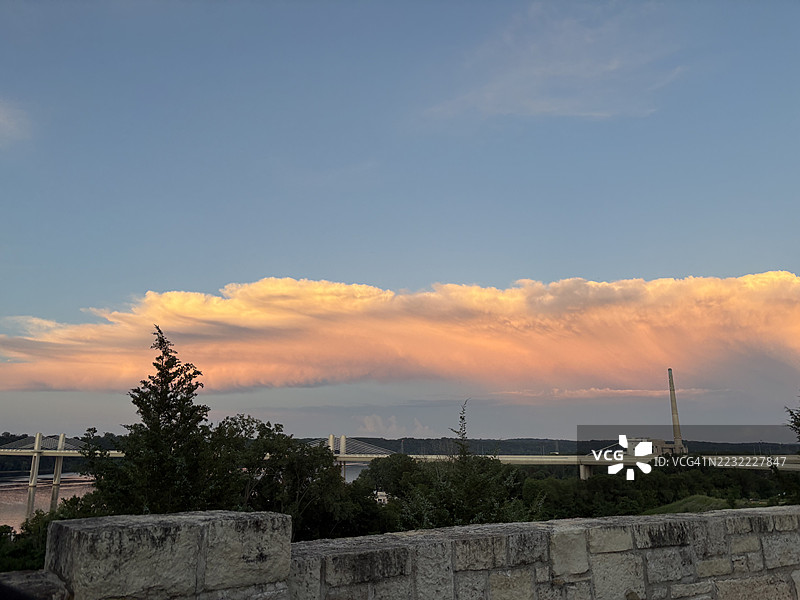 河上日落，桥梁与戏剧性的云彩图片素材