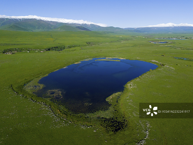 在蓝天的映衬下，绿色的山脉背景中，一片大型蓝色湖泊位于中央，鸟瞰图，水莲池，靠近萨拉托夫卡，亚美尼亚小高加索地区，洛里基特省。图片素材