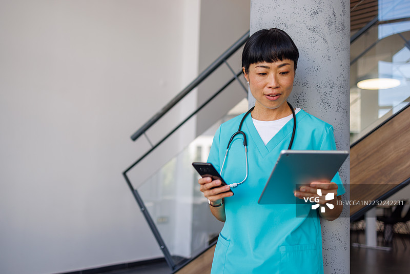 女医生在医院使用数字平板和智能手机图片素材