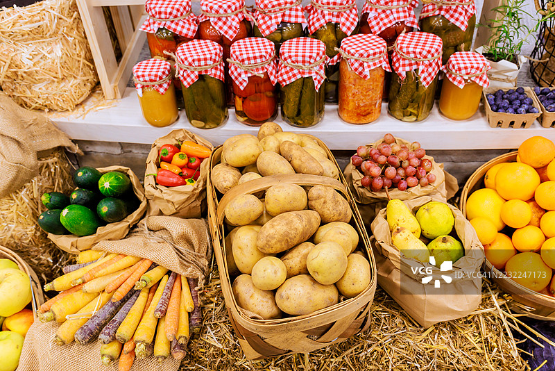 市场摊位上的各类新鲜农产品和保存罐图片素材