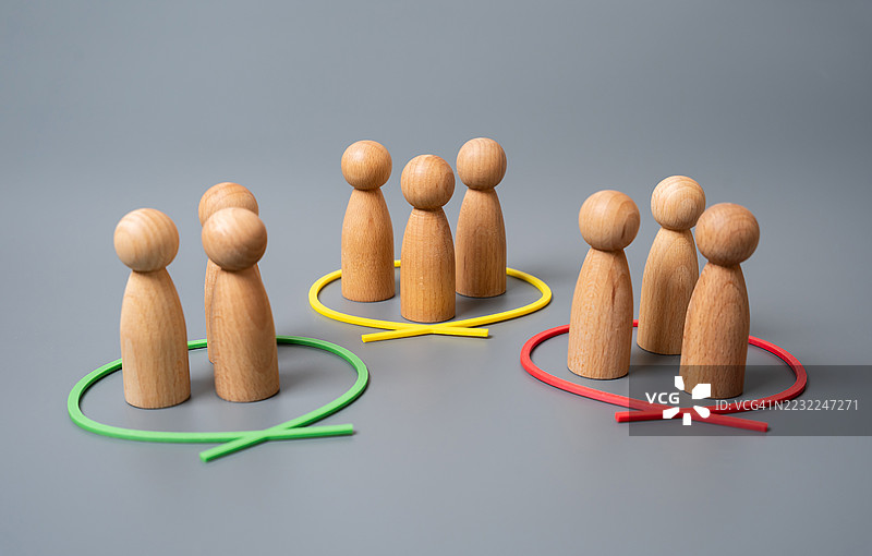 灰色背景上的木制雕像分组排列图片素材