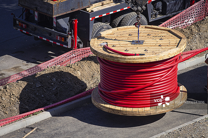 大红色电缆卷，正在城市施工现场升起，周围没有人。图片素材