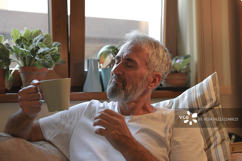 成熟男性在家中享受安静的茶时光图片素材