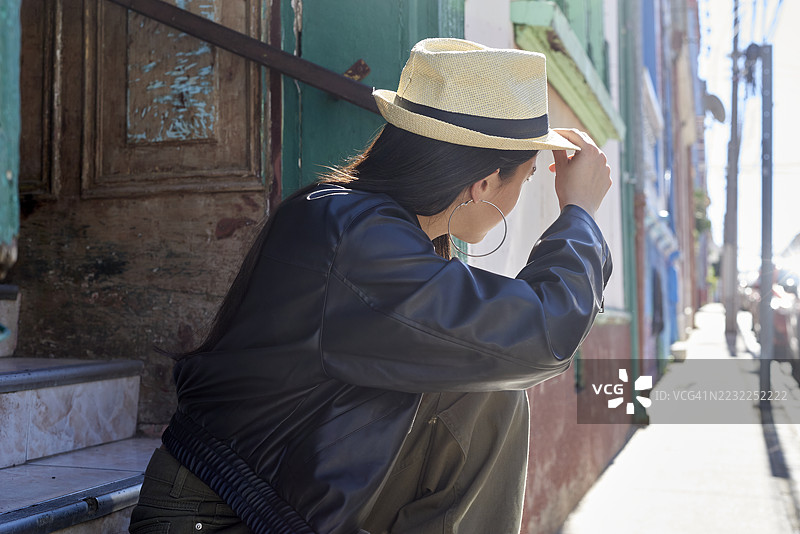 年轻的女游客在智利瓦尔帕莱索调整她的帽子图片素材