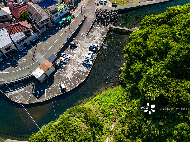 中木港的海港小镇风景。海滩外是一座大型的鬼岛。还有一艘从港口运输他们的渡轮渔船在运营。平藏滨海滩，中木港，南伊豆，伊豆半岛，静冈县，日本。- 2025年7月12日。图片素材