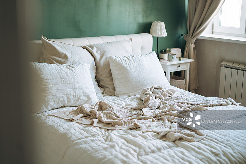 现代卧室室内，配有时尚的整洁床铺、自然光和简约的装饰细节图片素材