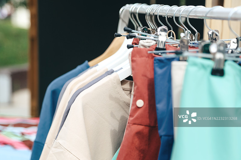 全景展示夏季柔和色彩的棉质套装、裤子和袖子挂在衣架上图片素材