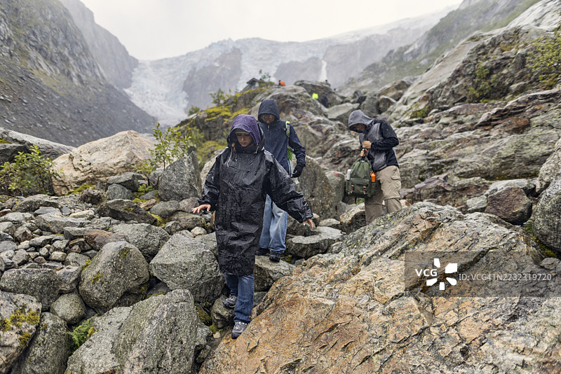 登山者在挪威Buarbreen附近的陡峭岩石坡道上下降，完成冰川徒步旅行。图片素材