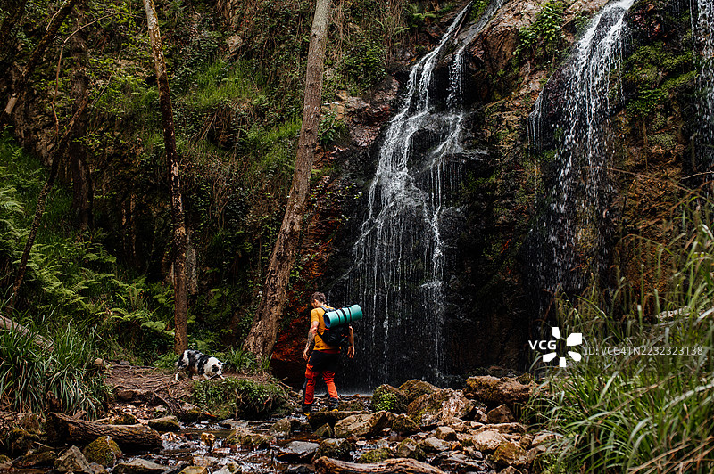 在西班牙阿斯图里亚斯探索关卡瀑布的徒步旅行者图片素材