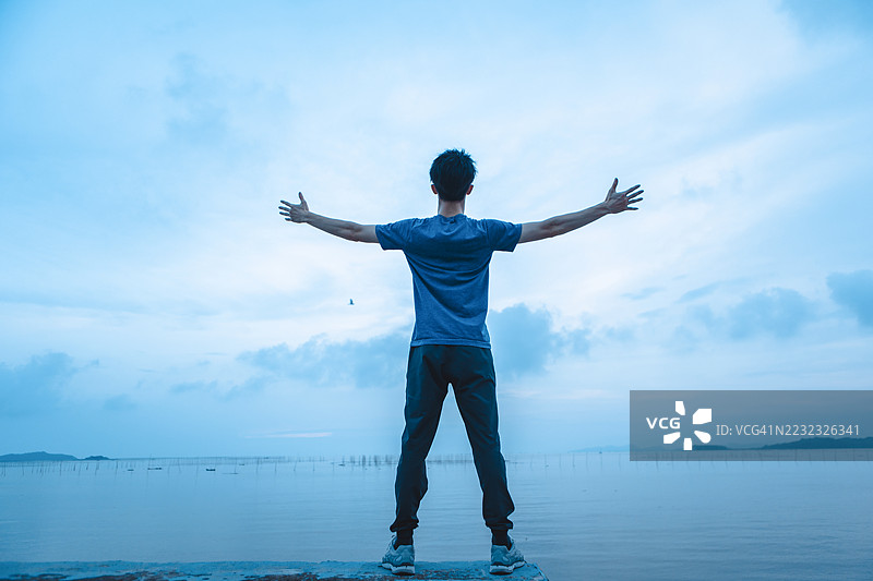 一个男人在海边观看日落图片素材