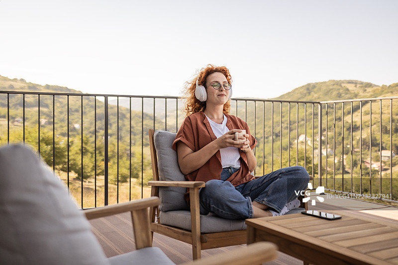 微笑的女性在户外享受智能手机和音乐图片素材