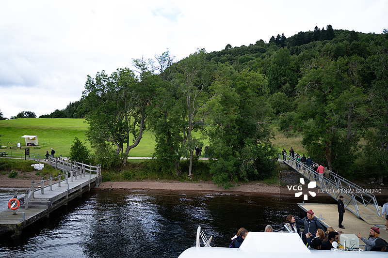 人们从游轮下来后在码头上行走图片素材