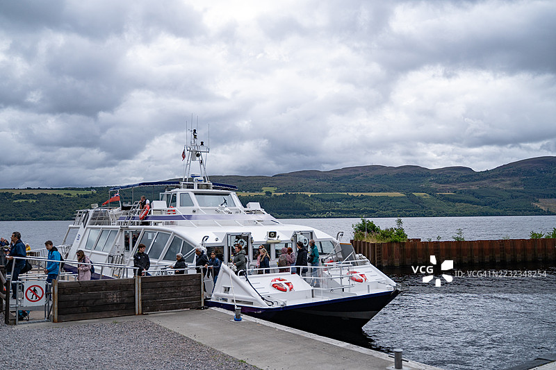 人们在码头离开湖上游船图片素材