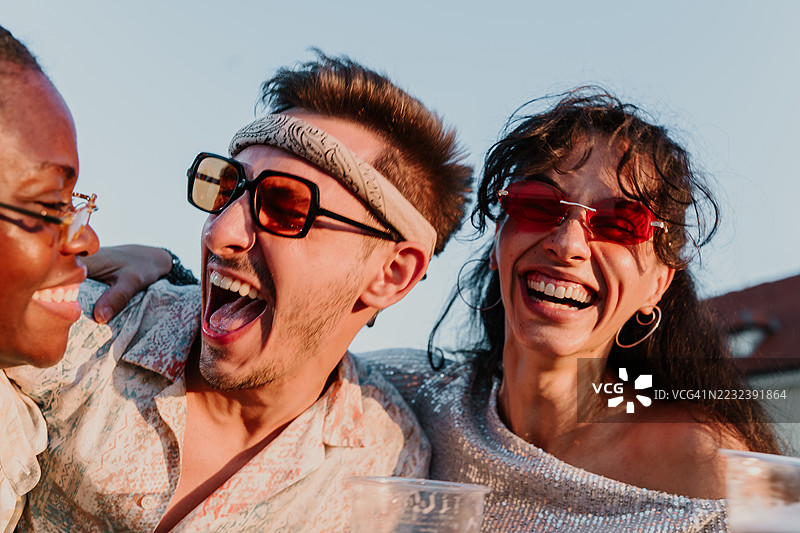 三位年轻人在户外欢笑在一起图片素材