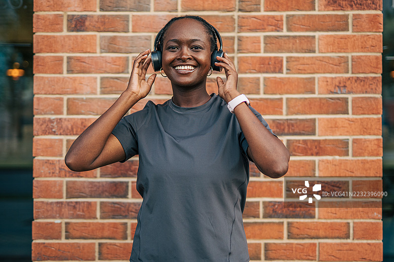 年轻的运动女性戴着耳机听音乐图片素材