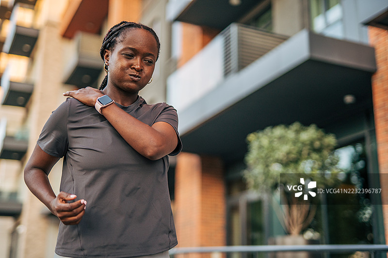 年轻女性在户外慢跑时感到肩部疼痛图片素材