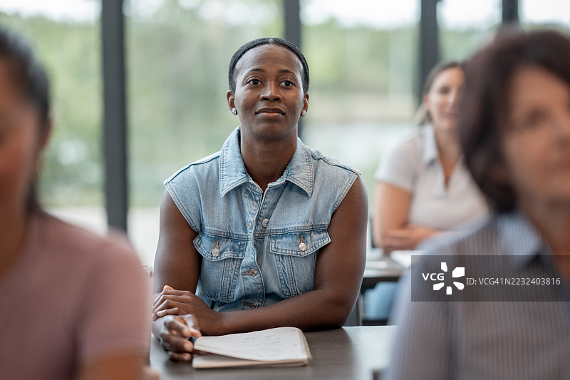 专注的女学生在明亮的教室里参加教育研讨会图片素材