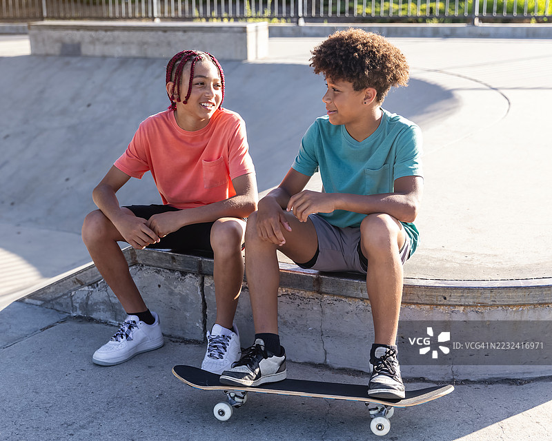 初中男孩在滑板公园走动并交谈图片素材