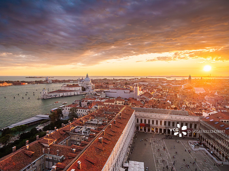 美丽的威尼斯日落航拍图，包含圣马可广场、圣马可区和多尔索杜罗区、大运河、朱代卡岛、几座教堂和钟楼，以及落日映照在地平线上，联合国教科文组织世界遗产 - 威尼托 - 意大利。图片素材