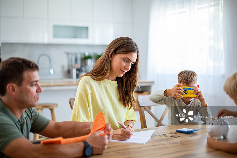 家庭在厨房桌子上共同管理家庭财务图片素材