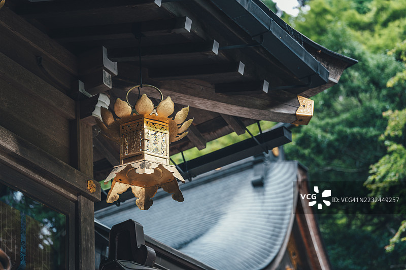 京都府岐阜根神社传统屋檐下悬挂的金色灯笼图片素材