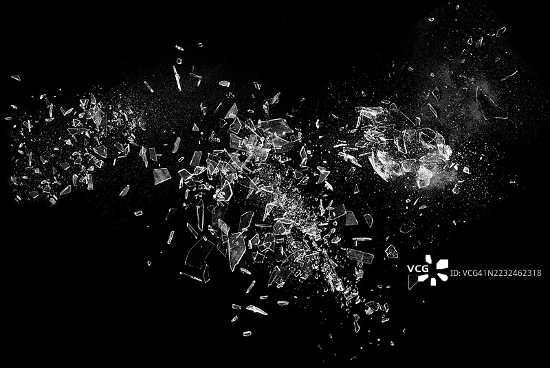 黑色背景上的破碎玻璃展示了碎玻璃的抽象纹理，细节丰富。该图像非常适合用作背景、纹理或抽象艺术项目。图片素材