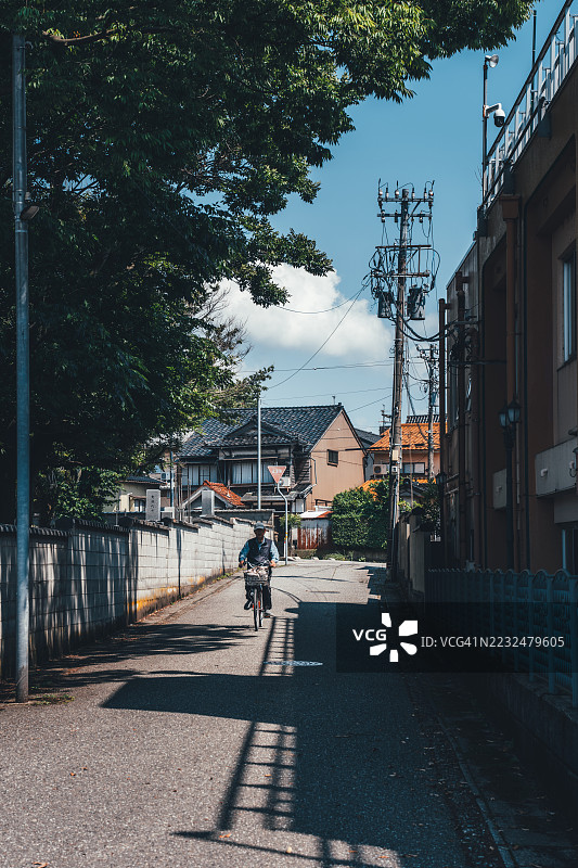 老年人在日本石川县金泽市安静的住宅街骑自行车图片素材