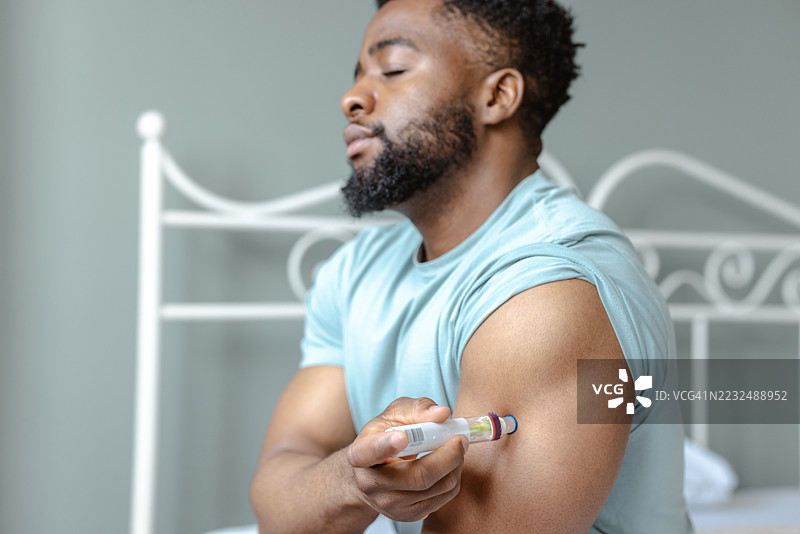 男子在医疗环境中为自己注射健康治疗。图片素材