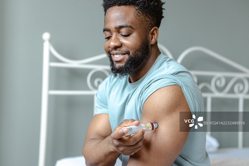 男子在医疗环境中为自己注射健康治疗。图片素材