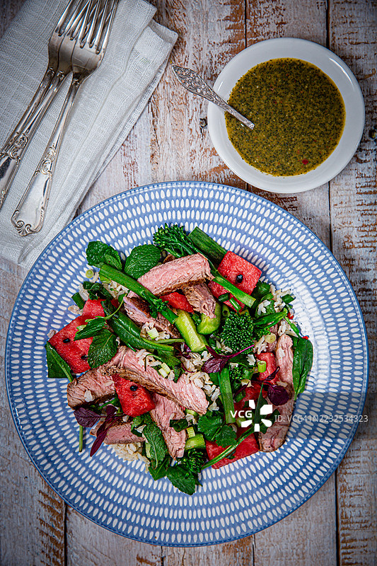 新鲜夏季沙拉配烤牛肉、西瓜和香草酱汁图片素材