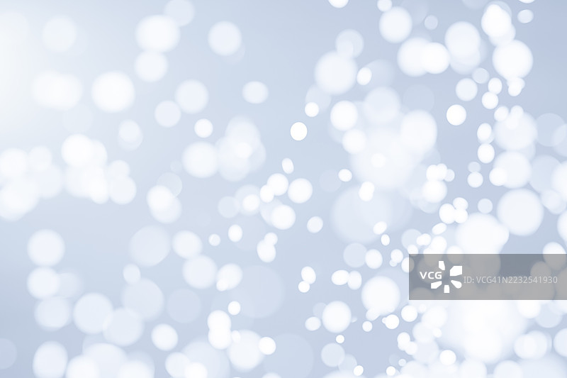 柔和的蓝色、银色和白色雪花抽象散景背景，带有模糊的光圈和闪烁的高光。极简梦幻质感，完美适用于冬季、圣诞节、假日、庆祝活动或干净现代的设计概念。图片素材