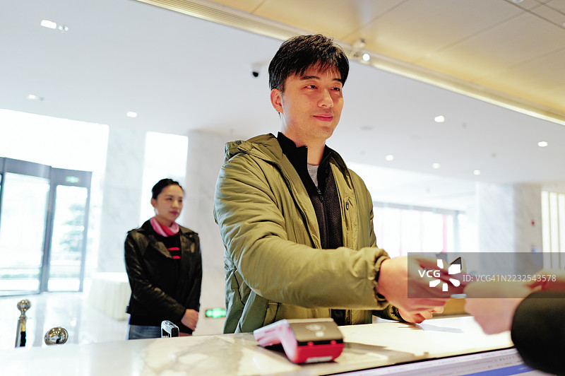 男士在酒店接待处付款 - 优雅与现代图片素材