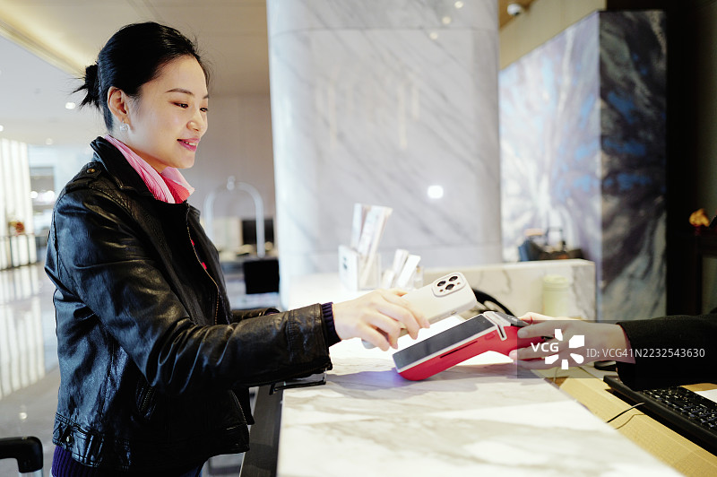 女性在酒店接待处付款 - 优雅与现代图片素材