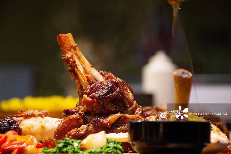 美味的羊腿肉特写，配有蔬菜和酱汁图片素材