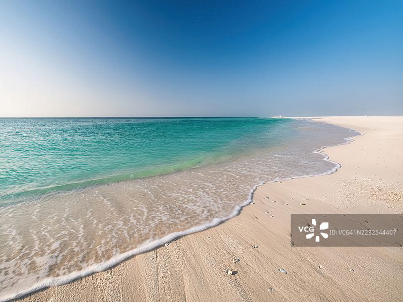 宁静的海滩，碧蓝的海水和晴朗的蓝天，阿联酋乌姆阿尔奎温图片素材