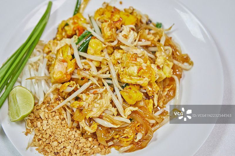 美味的泰式炒河粉配青柠和花生，摆放在盘子上图片素材