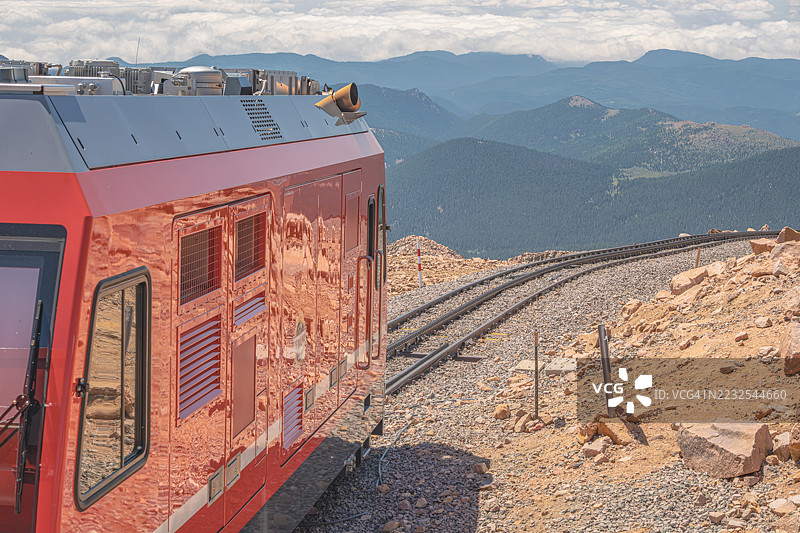 红色火车在风景如画的山上行驶图片素材