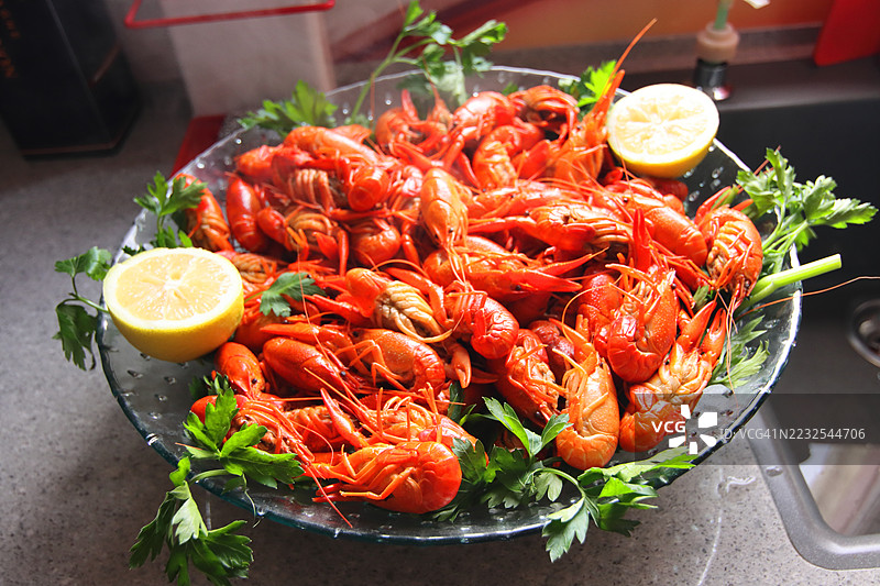 新鲜烹制的克氏原螯虾配柠檬和欧芹盛在盘子里图片素材