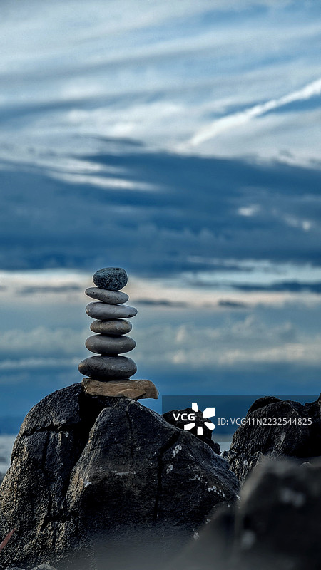 克罗地亚阴云密布的天空下，平衡的石头堆叠在岩石地形上图片素材