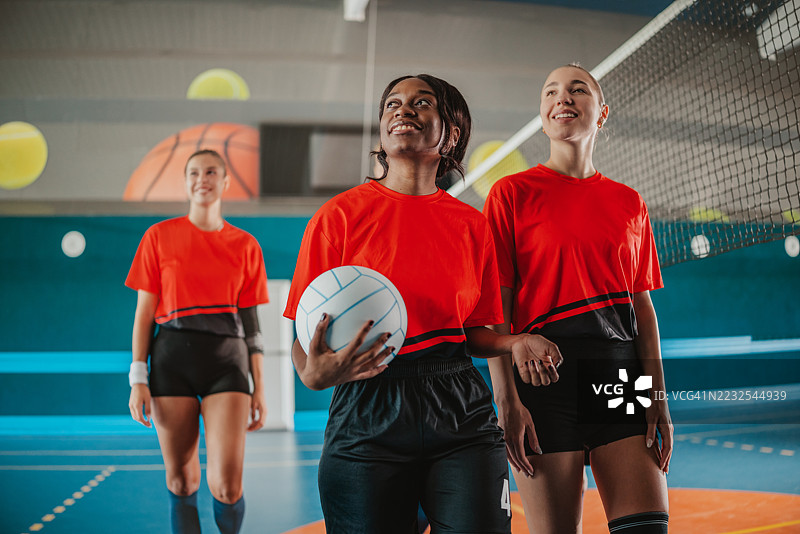 年轻女性在室内进行排球训练，在竞技环境中展现团队合作和运动精神图片素材
